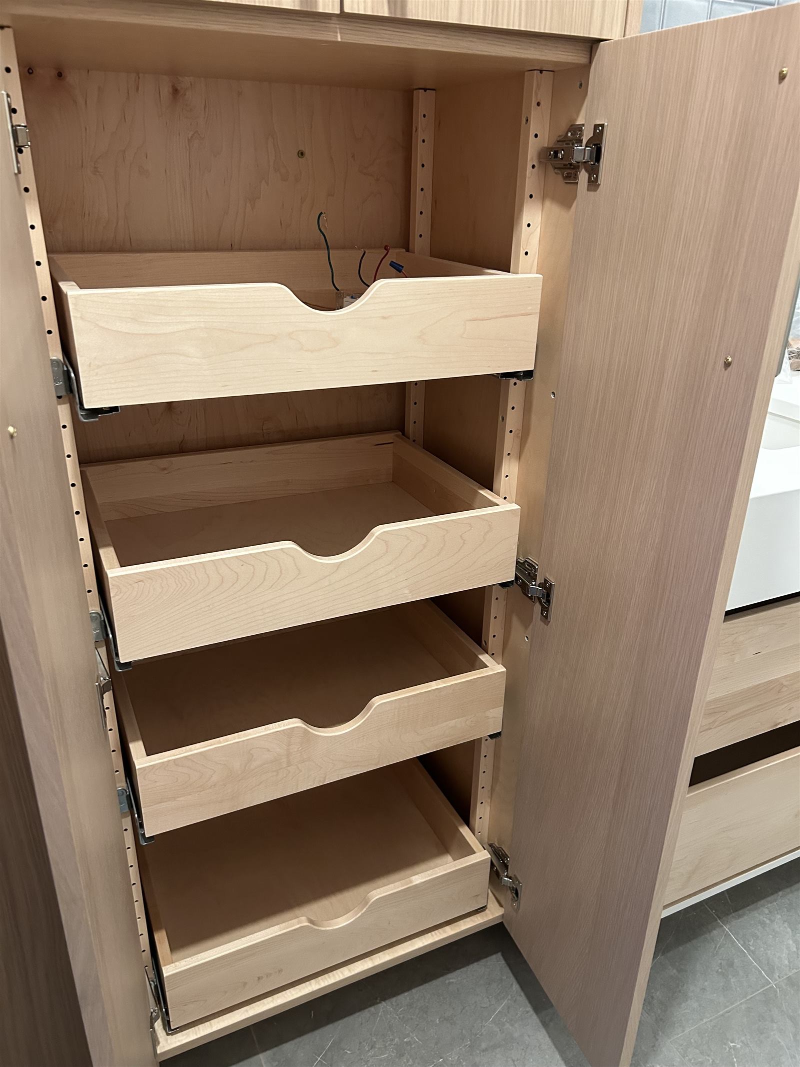 Close-up of custom cabinet joinery, hinges, and internal dividers during construction